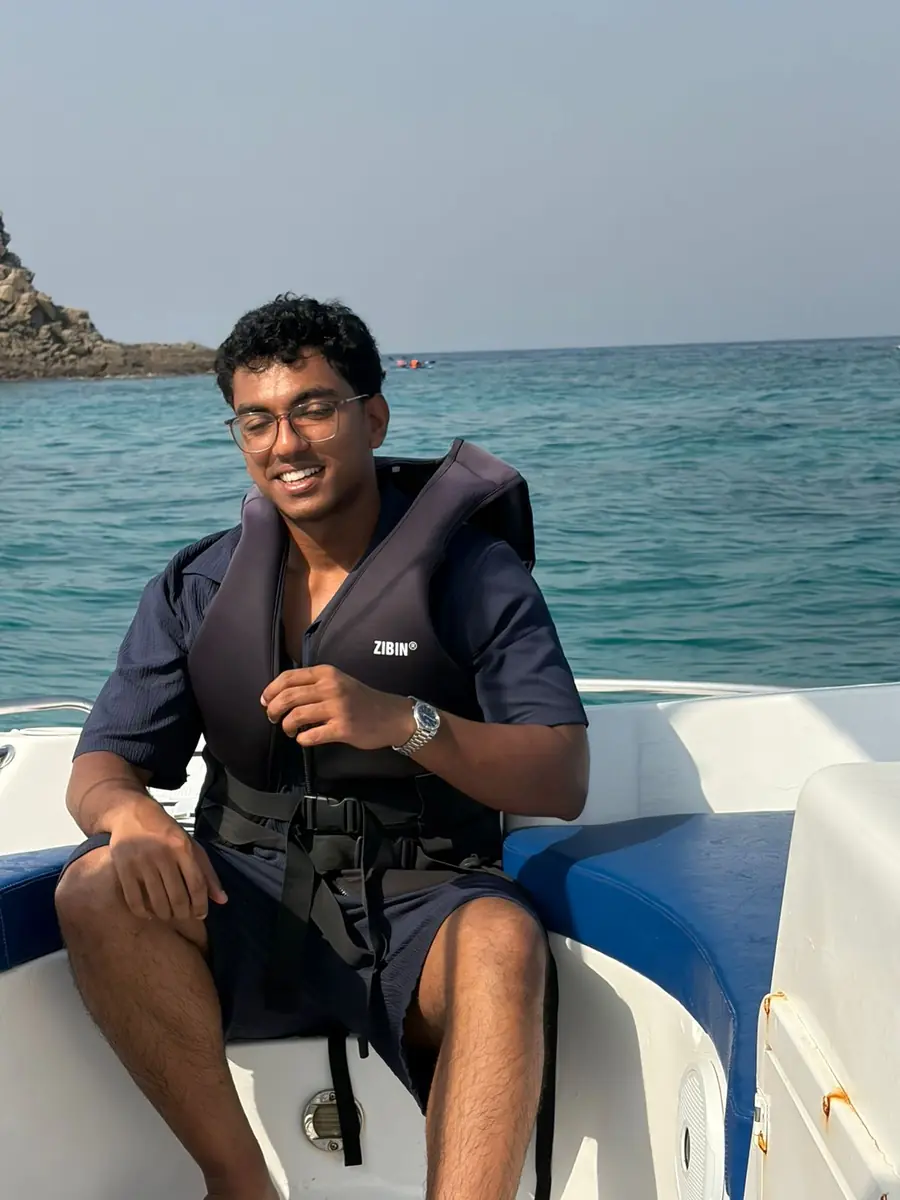 Meyshan smiling on a boat during time away from study
